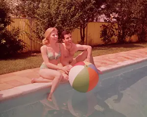 Beachball: 1960s Couple Sitting On Edge Of