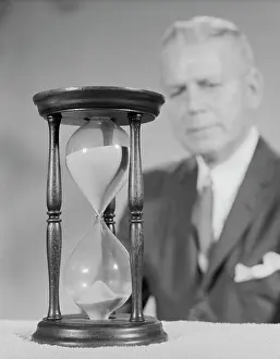 Sandglass: 1960s ELDERLY MAN SOFT FOCUS BEHIND HOURGLASS