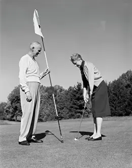Putt: 1960s elderly woman getting ready to putt while
