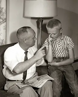 Disciplining: 1960s Father Disciplining Upset Crying Son