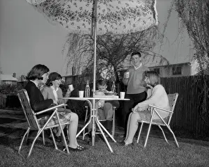 Clique: 1960s GROUP TEENS SITTING IN BACKYARD UNDER LAWN
