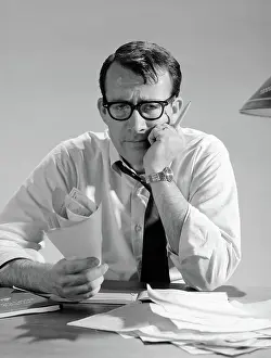 Businesspeople: 1960s MAN WITH PILE OF BILLS AND WORRIED EXPRESSION