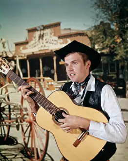 Strumming: 1960s Man Playing Acoustic Guitar