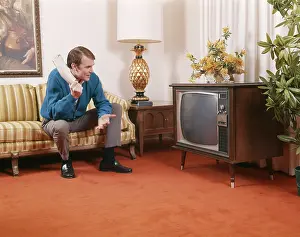 Newsprint: 1960s Man Sitting On Sofa Holding