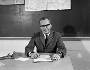 1960s Man Teacher At Desk In Classroom