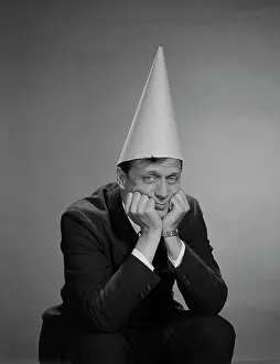 Idiot: 1960s MAN WEARING DUNCE CAP