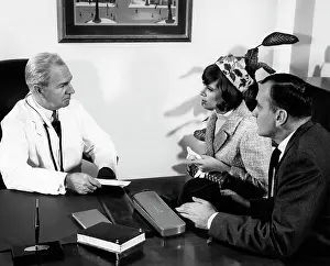 Obstetrician: 1960s Older Man Doctor In Office