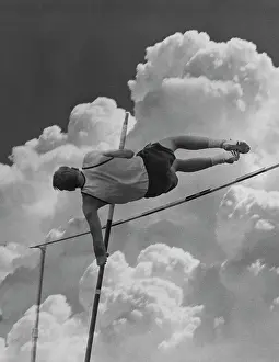 Strive: 1960s POLE VAULTER MAN AGAINST SKY AND CLOUDS