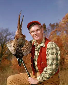 Colchicus: 1960s Smiling Man Hunter looking at Camera Holding up Har