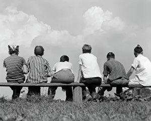 Leaguer: 1960s BACK VIEW OF SIX BOY BASEBALL PLAYERS SITTING