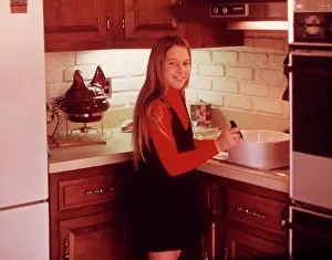 Ager: 1960s Young Girl Cooking In Kitchen