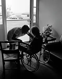 Providers: 1970s anonymous silhouetted nurse helping elderly