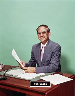 1970s Smiling Man At Desk With