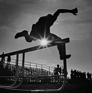 Sunburst: 1970s SUN RAYS THROUGH SILHOUETTE OF MAN JUMPING