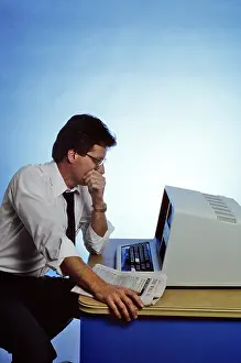 Fel001: 1980s Man Sitting at Computer looking Tired Worried