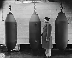 Inspecting: 2, 000-pound bombs hanging from a huge shell-loading