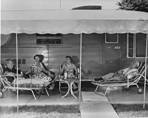 Loungers: 2 older couples sit under the awning of their mobile home