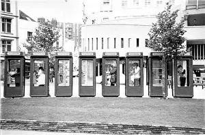 Belisha: 5 People on phone in a row of 8 telephone boxes