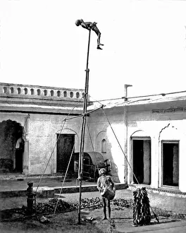 Acrobats: Acrobat on a pole, with drummer below, India