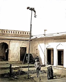 Acrobats: Acrobat on a pole, with drummer below, India