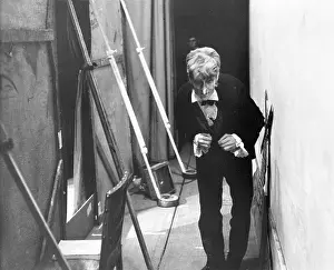 Hunched: An actor waits behind the scenery