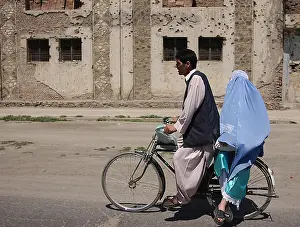 Taliban: An Afghani couple rides a bicycle through ?