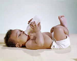 Diaper: African American Baby Lying on back Drinking from Bottle