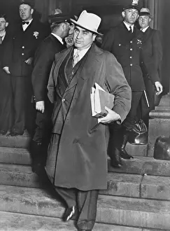 Winks: Al Capone, winks at photographers as he leaves