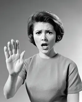 Hinder: Alarmed woman holding up her hand to stop something