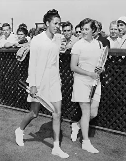 Qualifying: Althea Gibson and Barbara Knapp walk on grass at