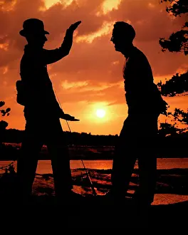 Exaggeration: Anonymous Silhouette of Two Men One Wearing Hat