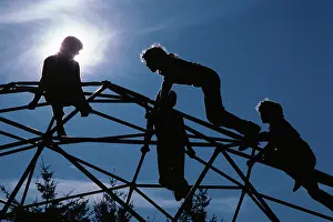 Geodesic: Four Anonymous Silhouetted Kids Climbing on Geodesic