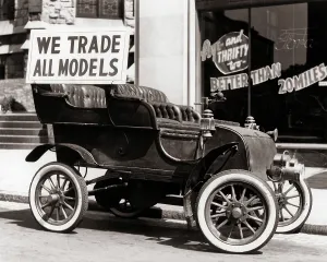 Dealership: Antique Car with We Trade All Models Advertising Sign