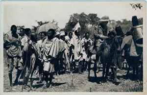 128th: Armed Italian officer on a mule with group of native bearers