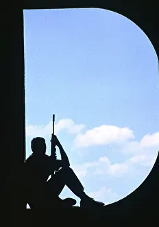 Aperture: An armed soldier - sitting in a D-shaped aperture