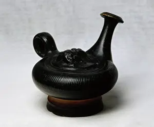 Decoratively: Askos. Central decoration embossed satyr head. Black varnish