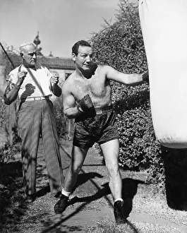 Workouts: Athlete with his trainer working on a punching bag