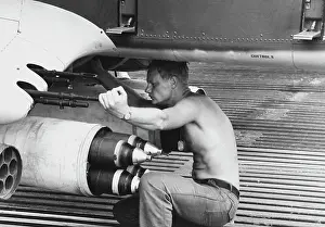 Underneath: Aviation Machinist Mate drains a fuel sample