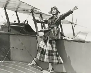 Bi Plane: Aviatrix standing on bi-plane