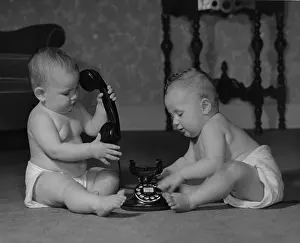 Diapers: Two babies sitting on the floor with old style telephone