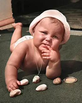 Thoughtful: Baby playing with pebbles