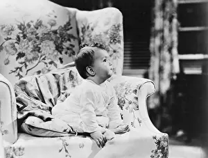 Dependence: Baby sitting on armchair