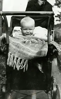 Lucinda Moore: A Baby smiling out from a large Perambulator