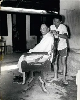 Cures: Barber at work in leprosy settlement, Sarawak