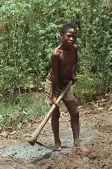 Freetown: Barefoot boy with mattock, Sierra Leone