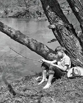 Pre Teen: Barefoot Boy Sitting Under Tree by Stream Fishing with Tw