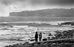 Breakers: Two beach fishermen with their rods and line
