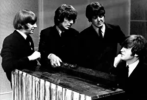 Ringo: The Beatles pop group, gathered round a piano