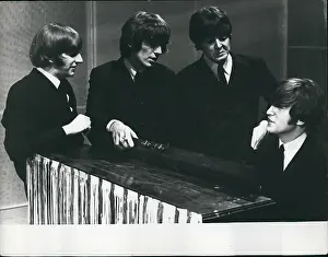 Ringo: The Beatles pop group, gathered round a piano