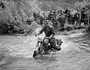 Negotiates: Biker crosses river